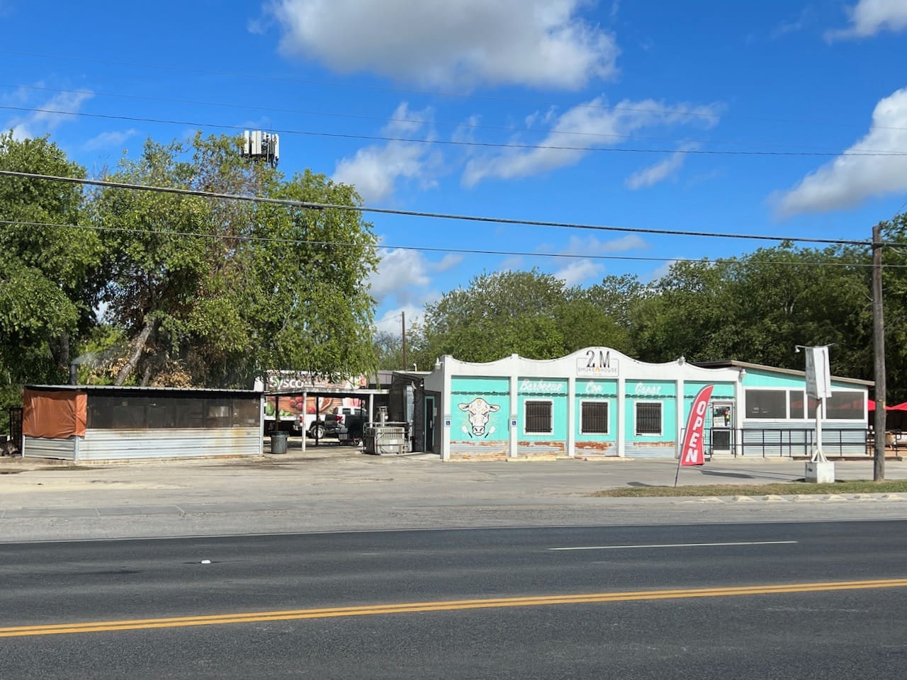 2M Smokehouse restaurant on right and bbq pit on left.