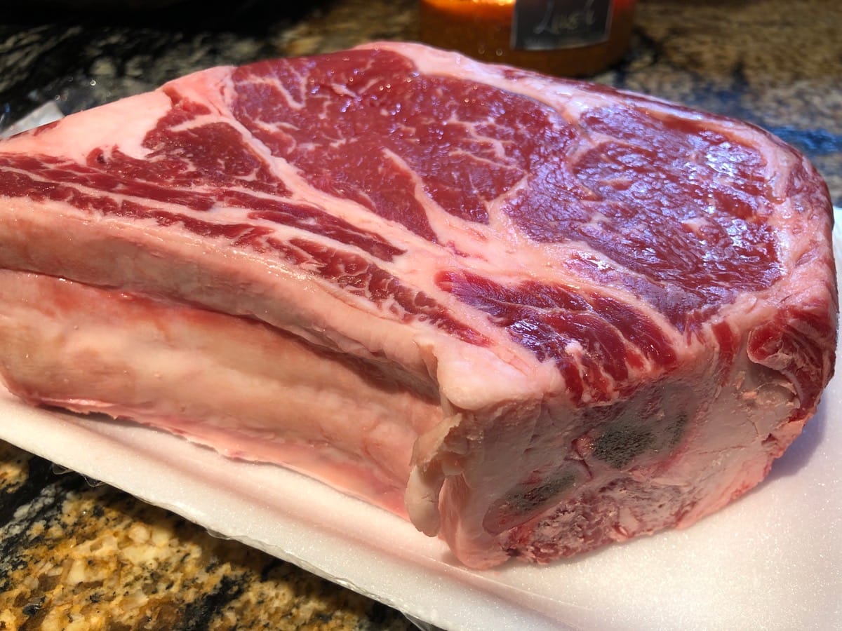 3lb Bone-in Ribeyes with beautiful marbling. We trimmed off the hard white fat you see picture because it won't render well.