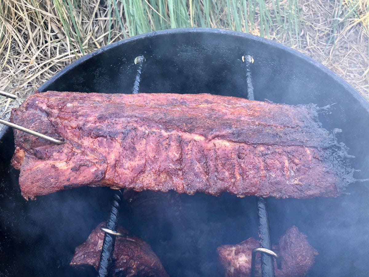 Baby back ribs laying over the rebar used to hang meat. You can sauce the ribs this way if you prefer. 
