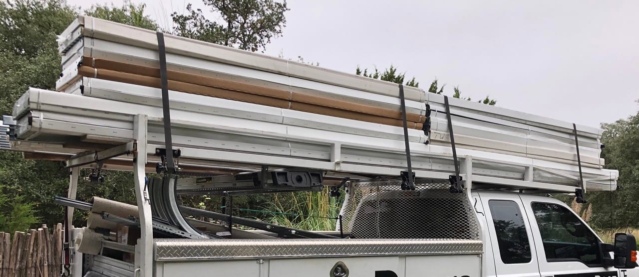 F-250 pickup with four Rack-Strap tie downs being used to secure new garage doors.