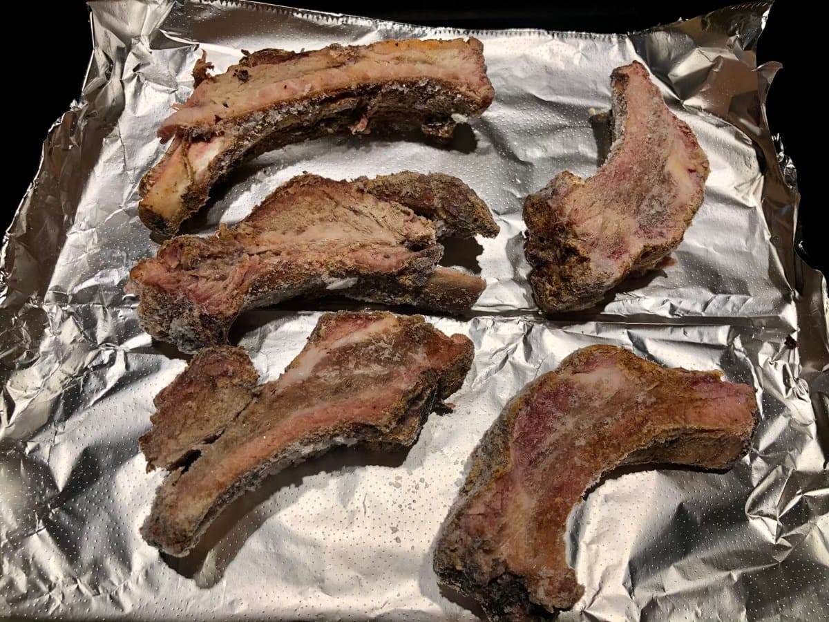 Frozen ribs on disposable foil sheet in kitchen oven