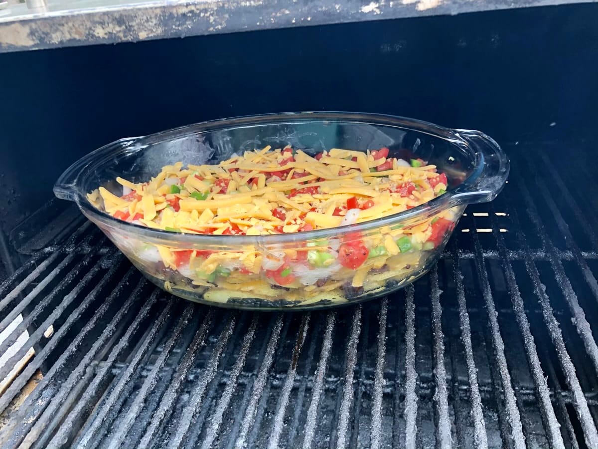 Irish Nachos layered with bacon, cheese, and veggies on MAK 2 Star pellet grill. The dish will be on for 10 minutes to allow the cheese to melt and the flavors to settle in.