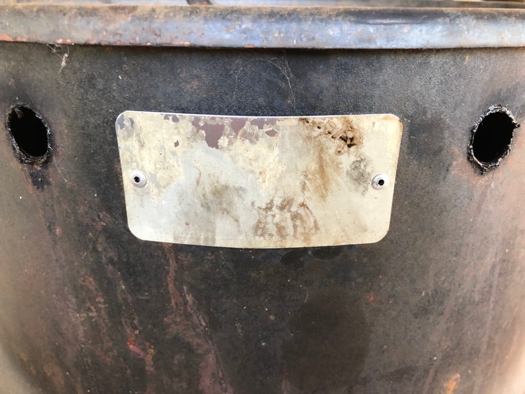 Two out of four holes used to hold the rebar that hangs the meat. These holes are where the smoke exits at the top. We have used this cooker so much we have worn off the name plate.