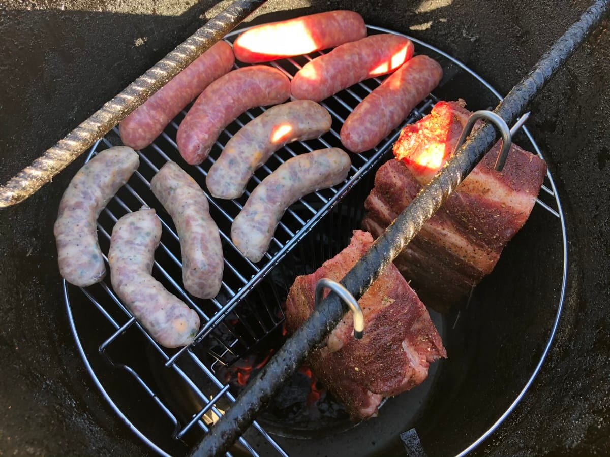 Sausages and beef finger ribs on the Pit Barrel Cooker using their hinged grate.