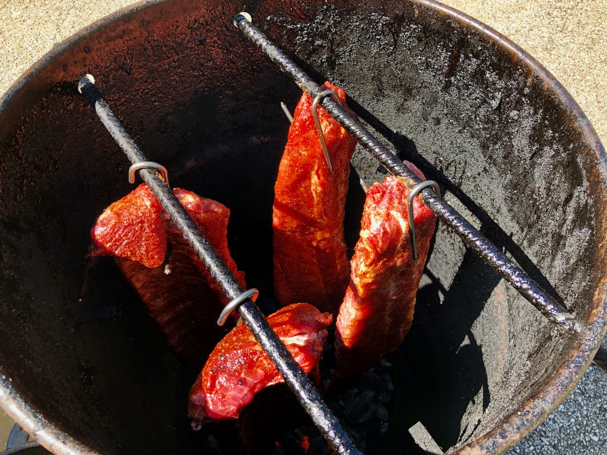 Hog Waller seasoned baby back ribs hanging on the Pit Barrel Cooker.