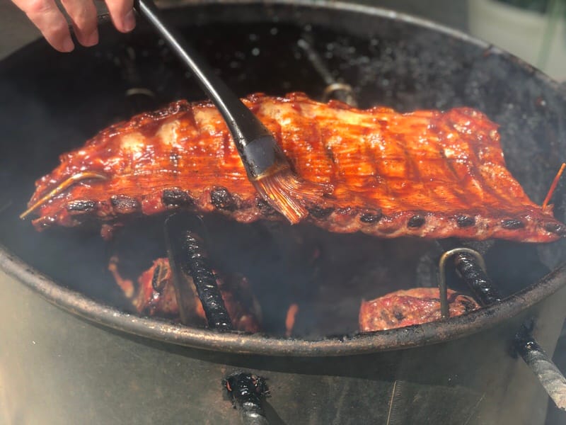 Saucing baby back ribs on Pit Barrel Cooker