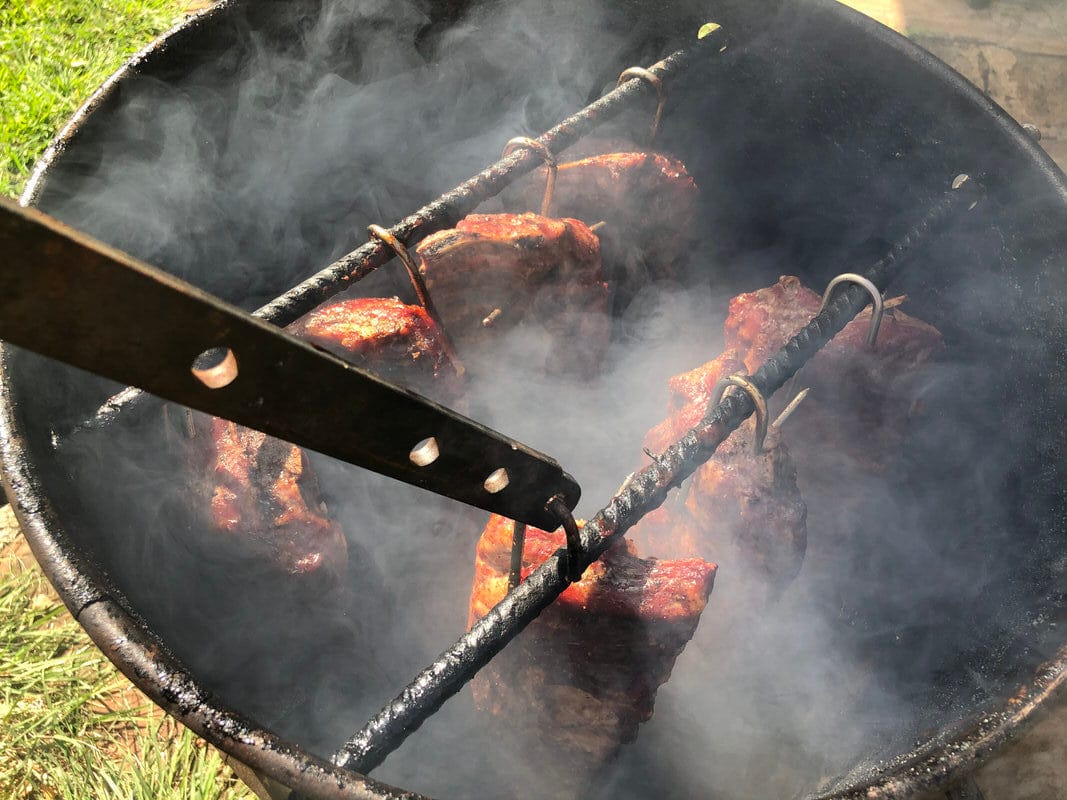 Seven racks of baby back ribs cooking at one time hanging over a live charcoal fire. What a beautiful sight!
