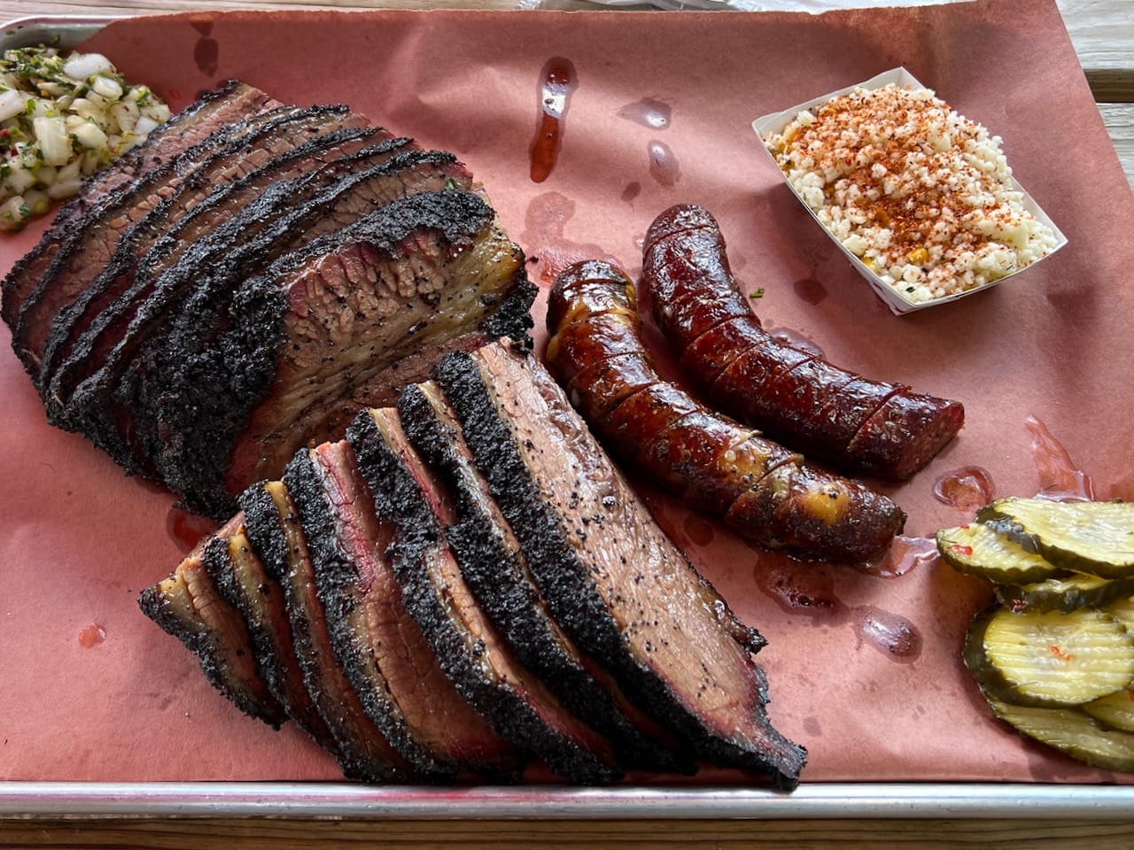 Smoked brisket, sausage, Mexican street corn, pickles, and onions at 2M Smokehouse in San Antonio, Tx.