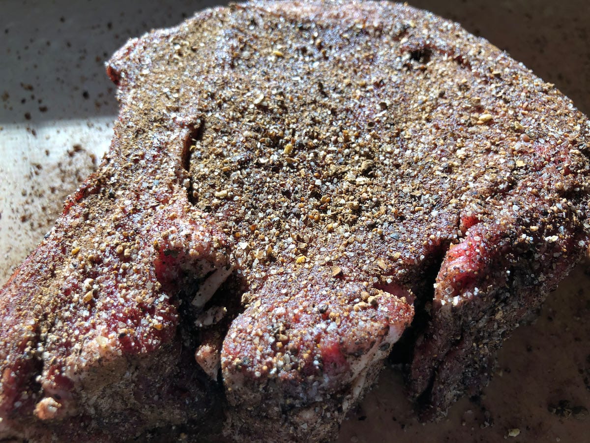 Tomahawk ribeye steak coated heavily with SuckleBusters Espresso Rub.