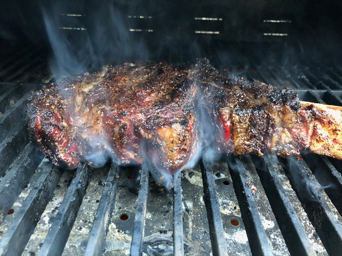 Tomahawk ribeye brought over from side smoker is getting its final sear.