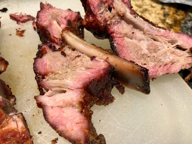 Fall off the bone baby back ribs with a beautiful smoke ring cooked on The Pit Barrel Cooker.