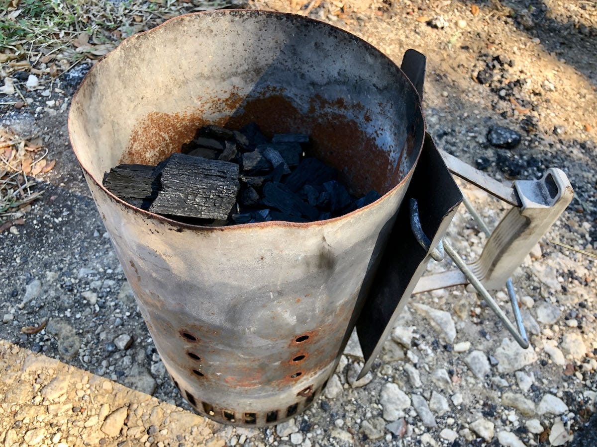 In a large Weber Charcoal Chimney, I start by filling the charcoal chimney half way. This will give you plenty of charcoal to get the fire started and move you forward through your cook.