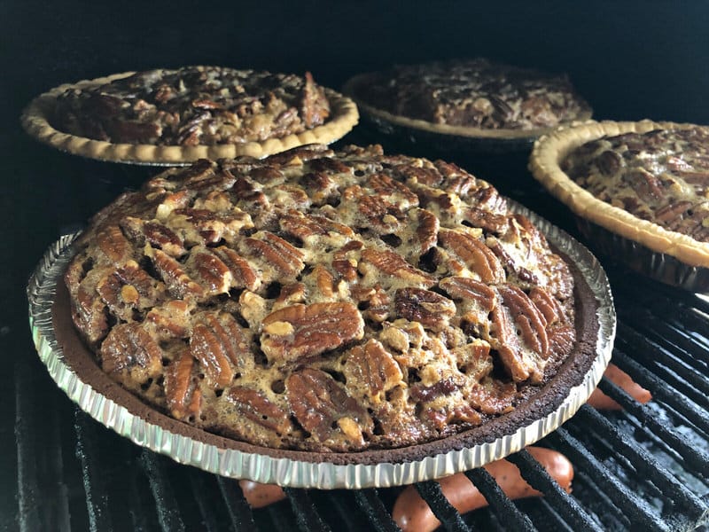 4 pecan pies baking on MAK 2 Star pellet grill upper rack. We even had a few sausages warming up on the bottom. Woohoo!