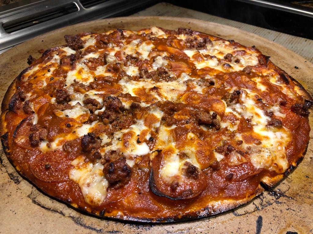 Thin crust pepperoni, ground beef, and provolone cheese pizza cooked on MAK 2 Star pellet grill