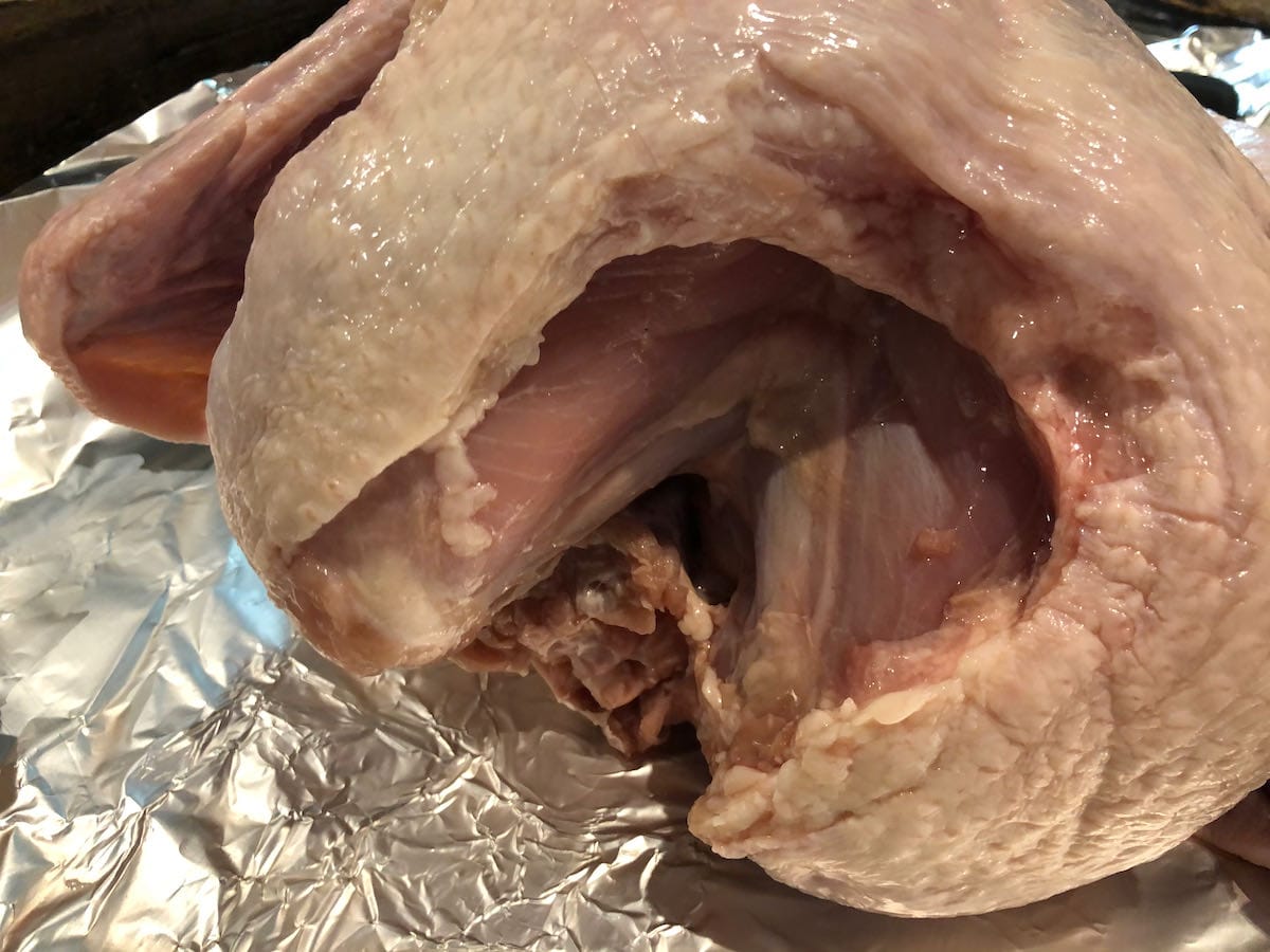 Raw turkey with skin trimmed up and giblets removed.