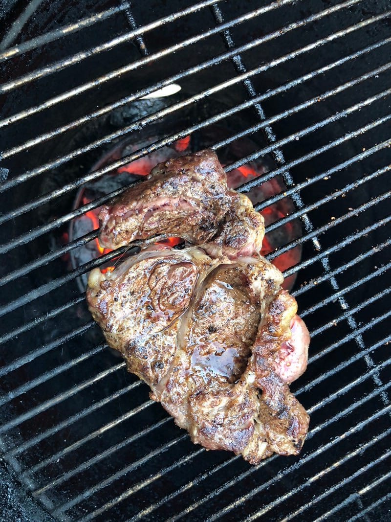 Ribeye steak over blazing hot charcoals on the Pit Barrel Cooker