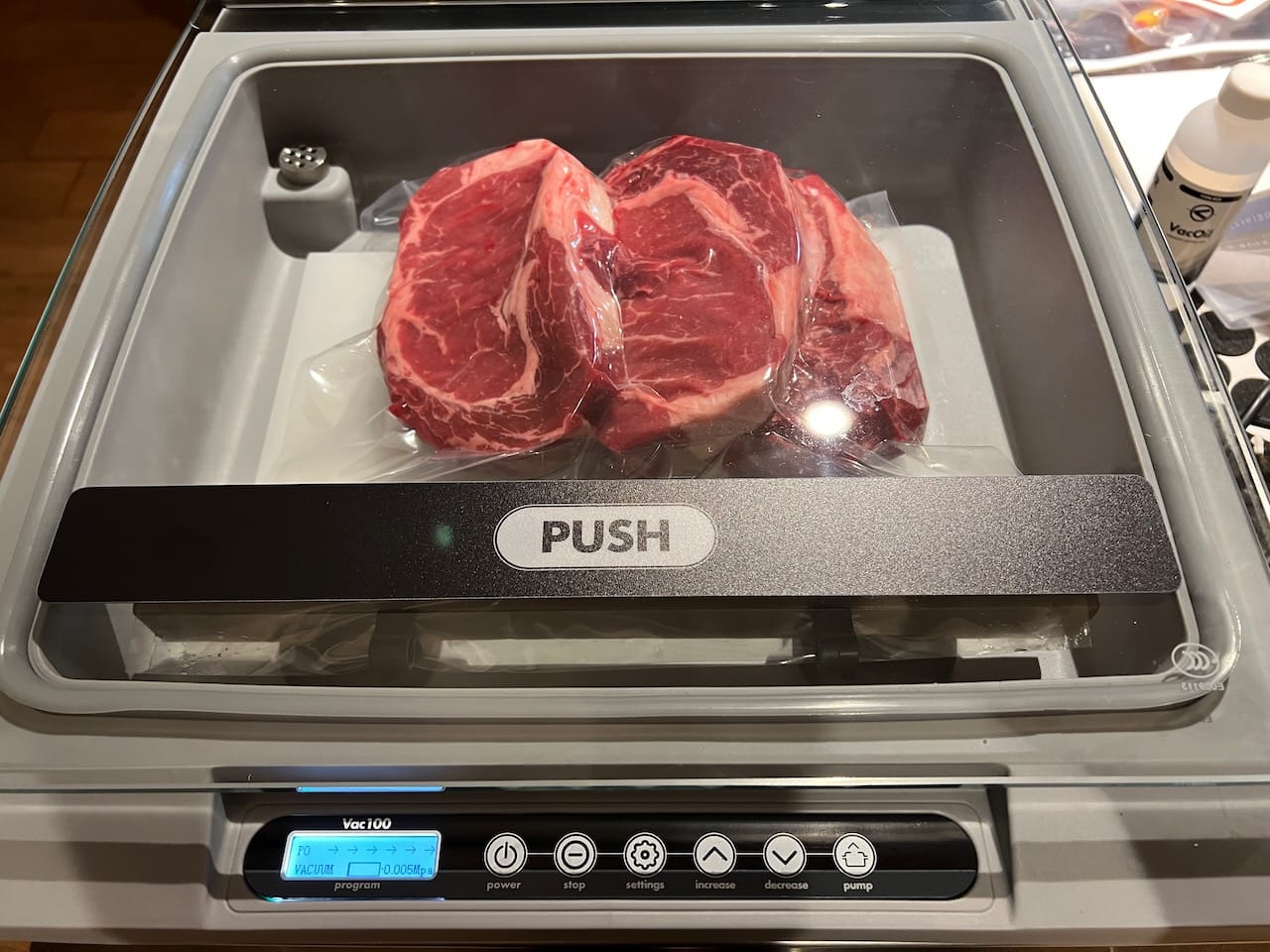 Three large ribeye steaks being vacuum sealed.