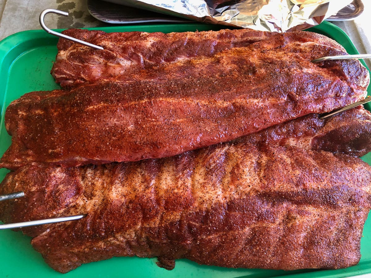 Baby back ribs seasoned on both sides with Hog Waller seasoning. Ready to hang over a live fire.