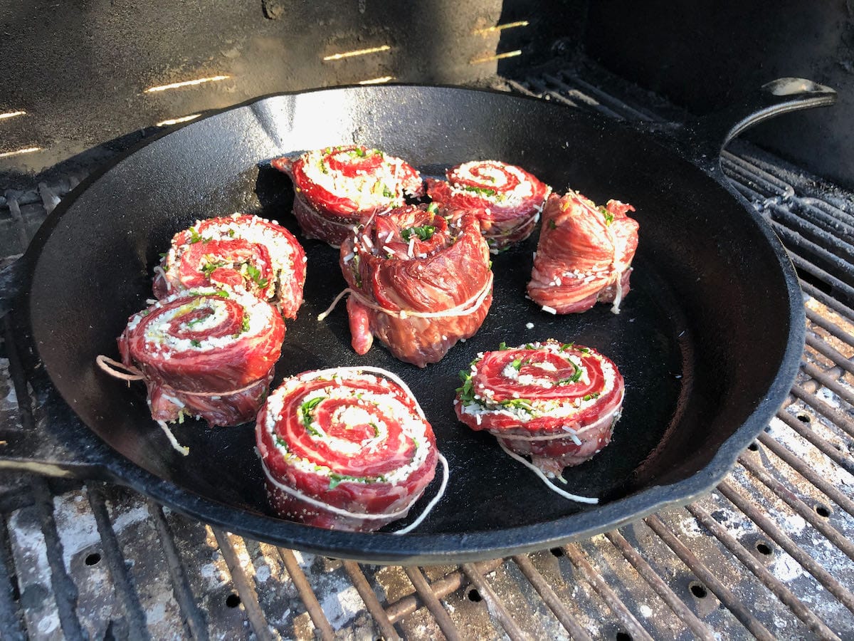 Pat LaFrieda skirt steak pinwheels in cast iron skillet on MAK 2 Star pellet grill.