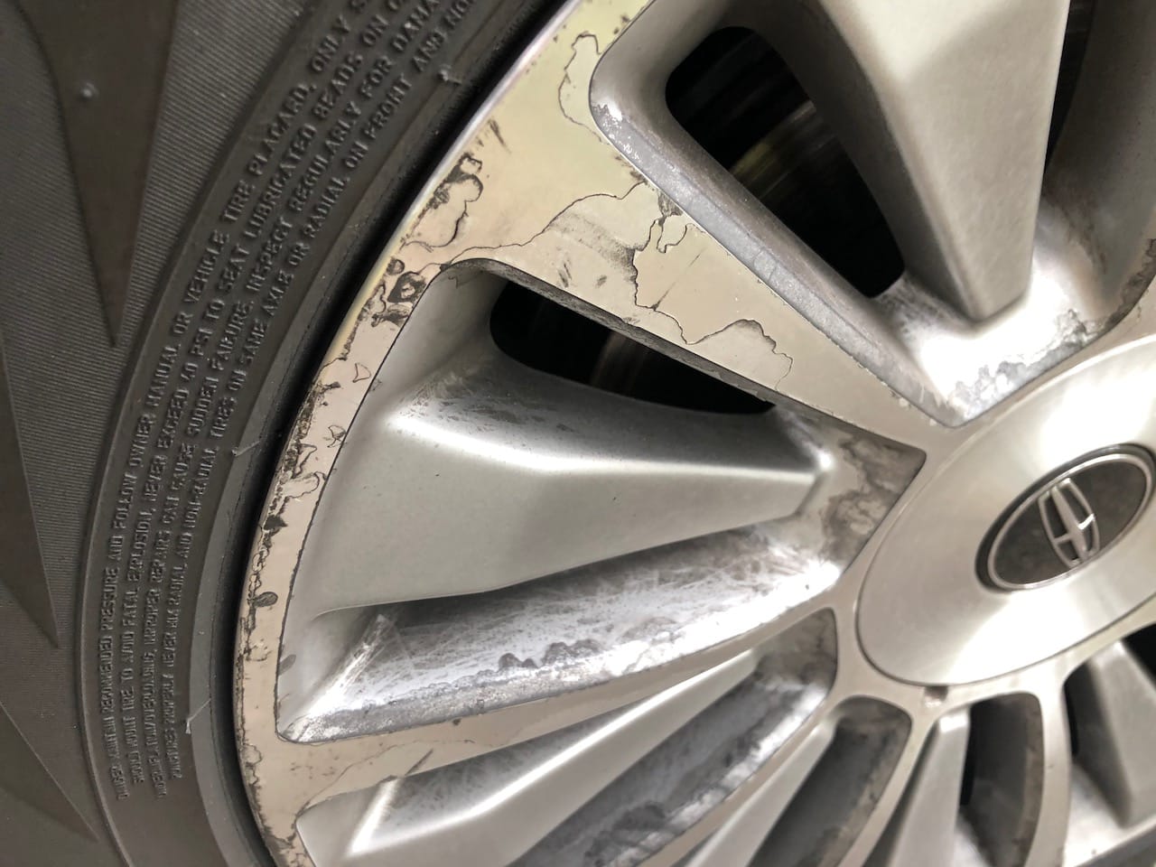 Before photo of factory two tone wheels on Lincoln Navigator peeling.